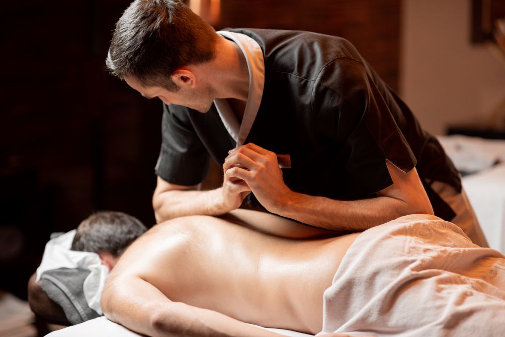 A male massage therapist massages his male client. Staying grounded: an antidote to our fast digital world.