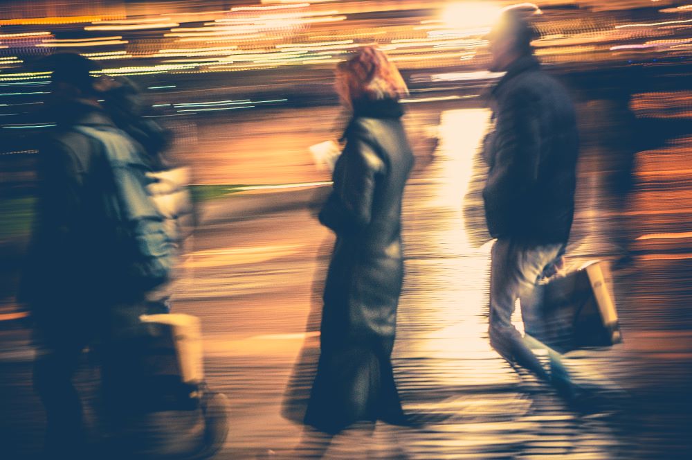 People walking fast at night depicting that life moves fast. The Healing Power of Sensual Touch: A Journey into the Calming Depths of the Nervous System.