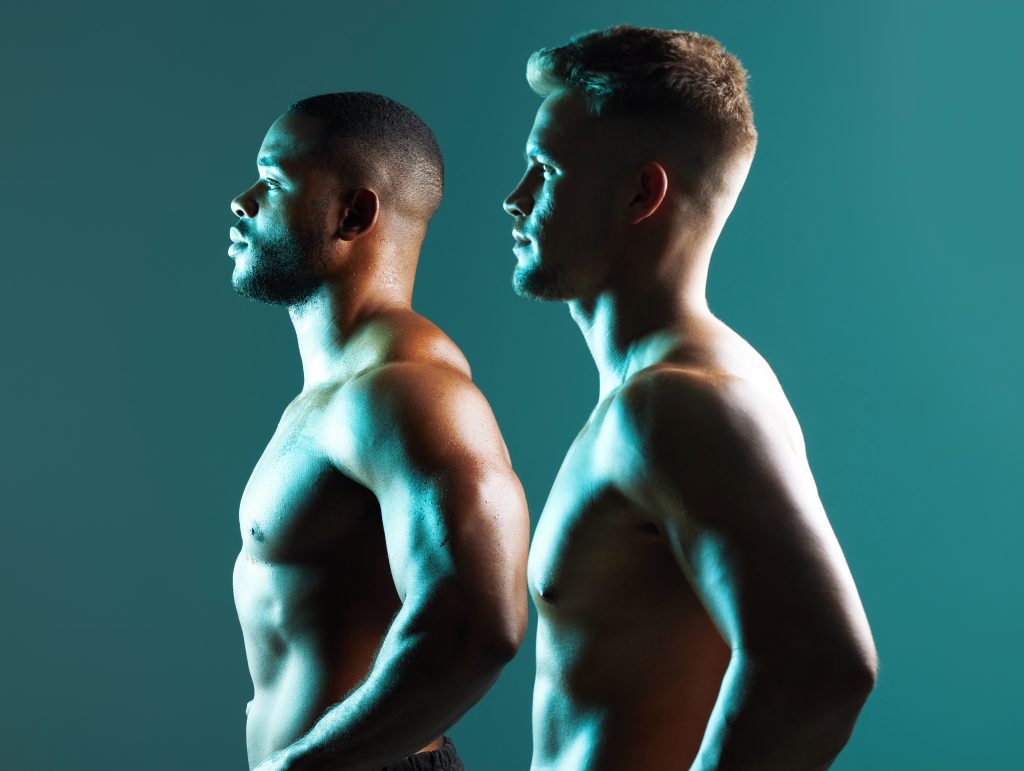 Two strong shirtless men, one white, one black standing tall and looking forward. Embracing Fluidity: Male Sexuality, Cultural Shifts, and the Power of Erotic Massage
