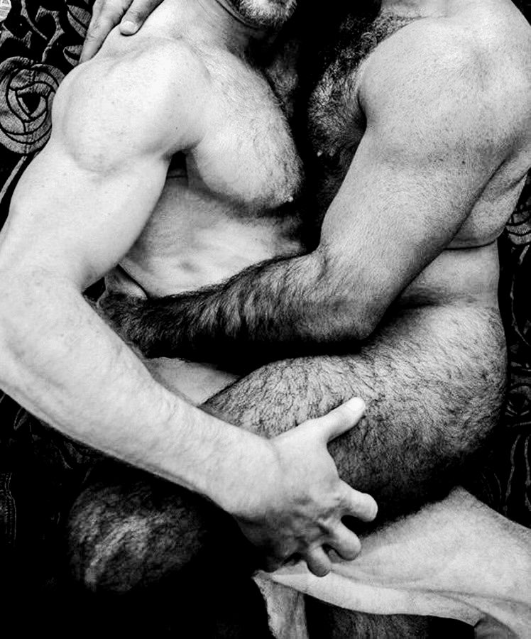 Close-up black and white artistic photo of two naked men in a body-to-body contact embrace.