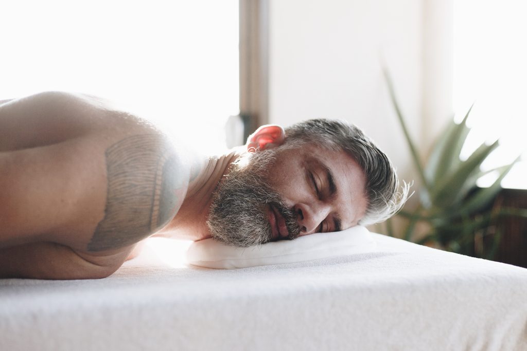 close up of a man laying on a massage table, eyes closed and relaxing. Behind the Scenes: What I Notice with Clients Seeking Male Erotic & Sensual Massage