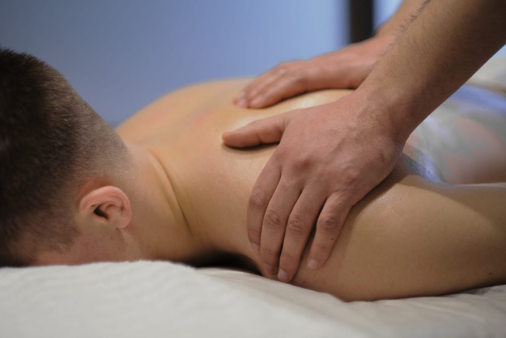 BodGround massage services. A male masseur massages his male client.